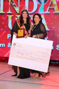 Khushi Patel - Miss India Worldwide 2022 receiving a plaque and her prize money of $8000.00 from Neelam Saran